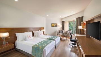 A hotel room with two beds, a desk, a TV, and a chair.