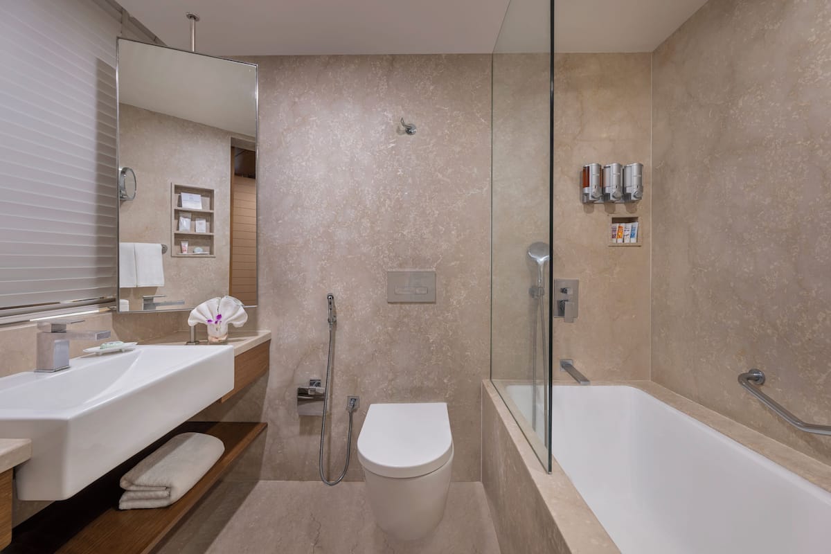 Ein modernes Badezimmer mit einer Duschkabine, einer separaten Toilette und einer freistehenden Badewanne.
