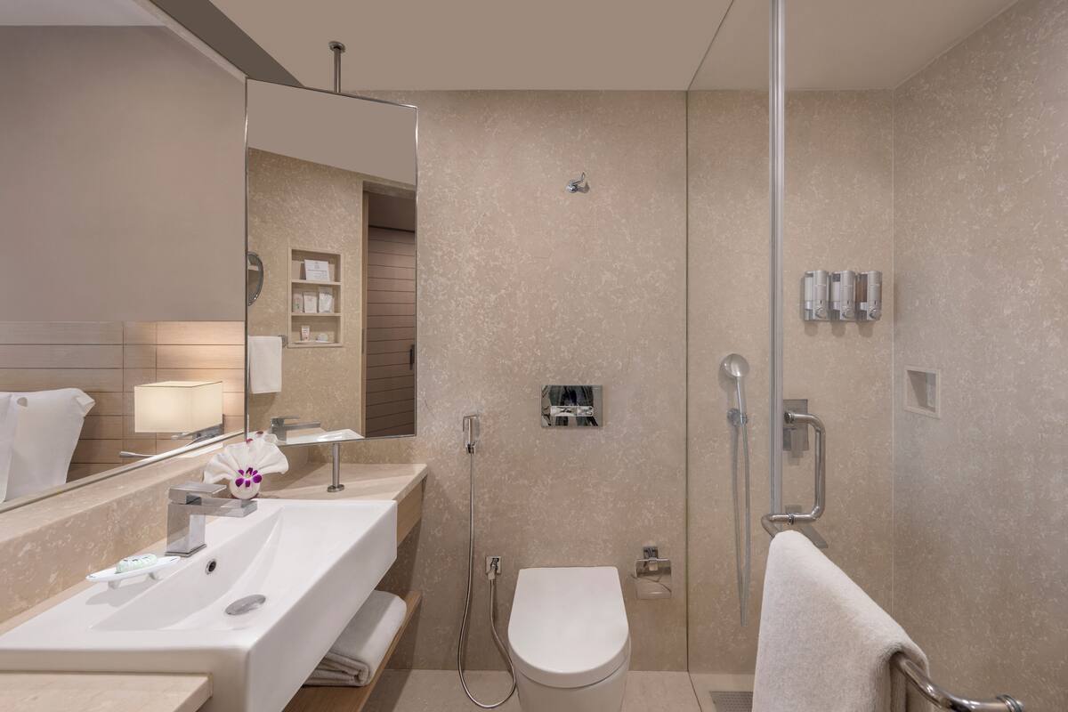 Ein modernes Badezimmer mit Waschbecken, Spiegel, Toilette und Dusche.