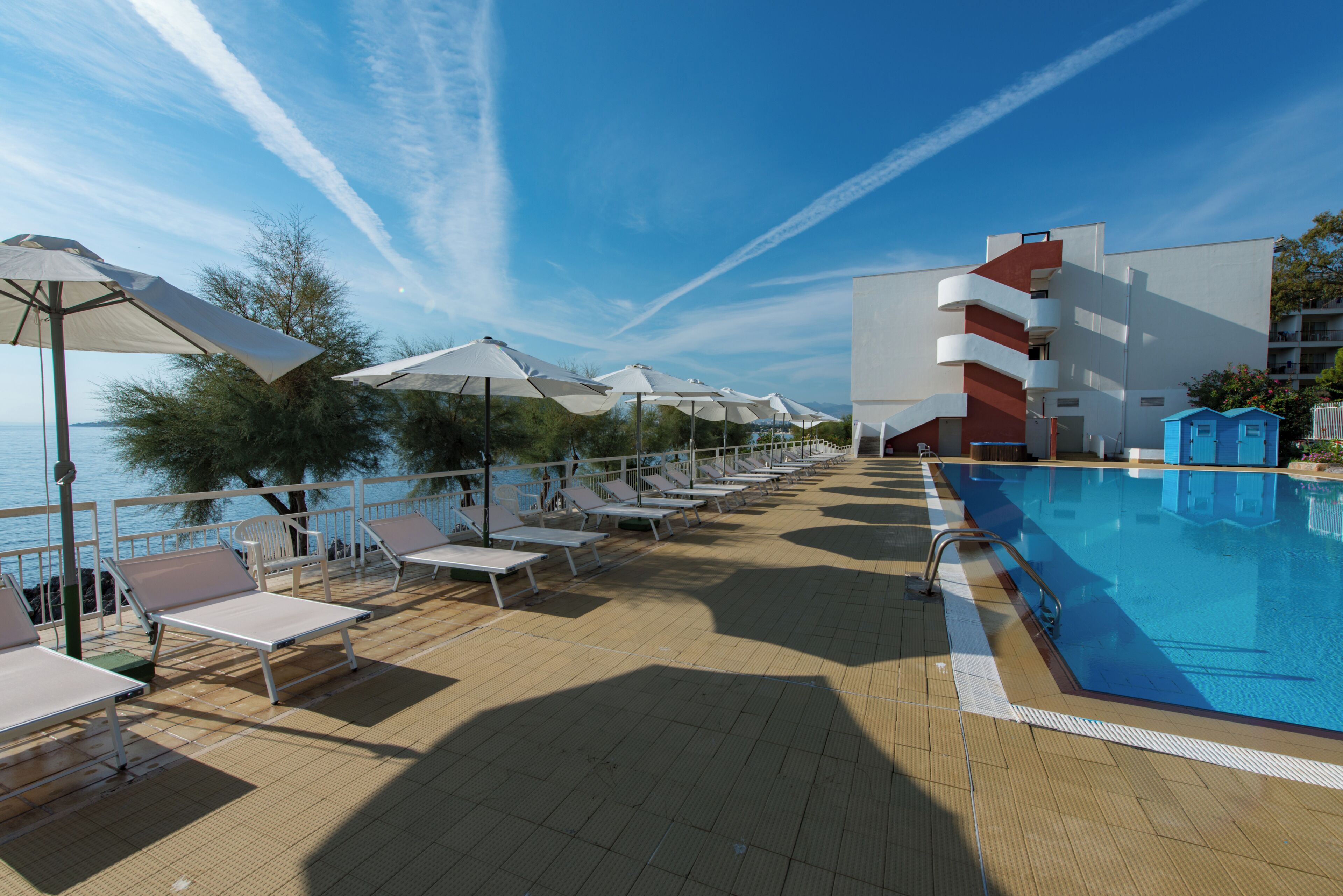 Una piscina al aire libre de temporada, sombrillas