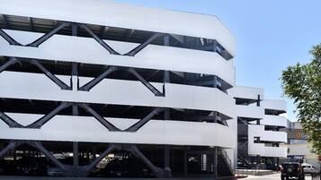 Un estacionamiento de varios pisos con diseño moderno, que presenta un patrón geométrico de paredes blancas y elementos estructurales negros.