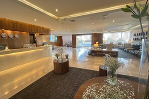 A modern hotel lobby with a reception desk, seating area, and large windows. - Wyndham Garden Tijuana Palacio Azteca (Tijuana)