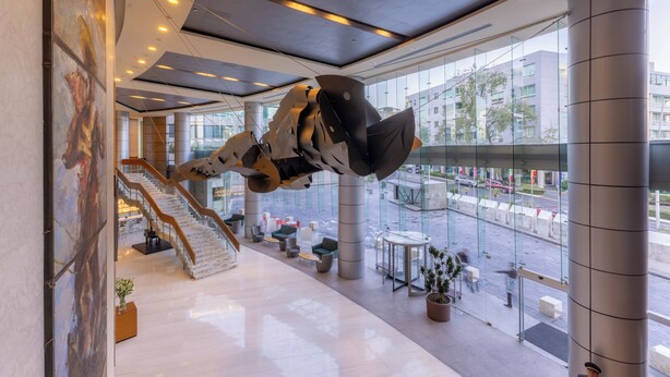 A modern interior with a staircase, seating area, and large windows overlooking the street. - Barceló México Santa Fe (Mexico City)