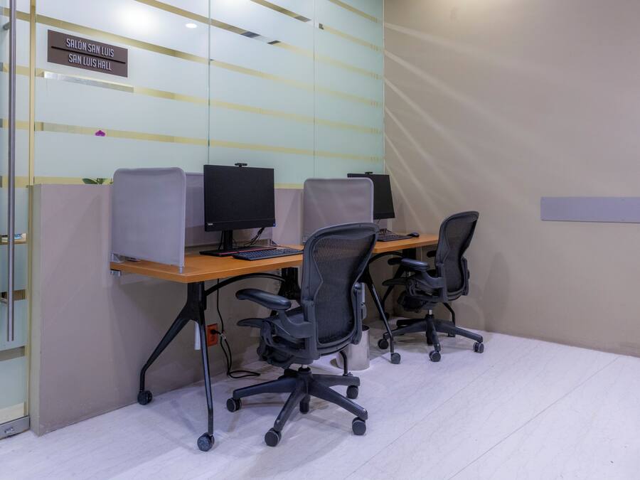A modern office space with cubicles, computers, and ergonomic chairs.