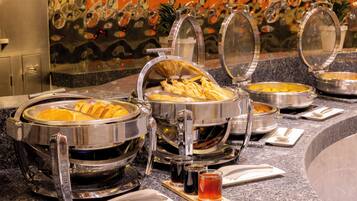 A buffet setup with various food containers and a beverage dispenser.