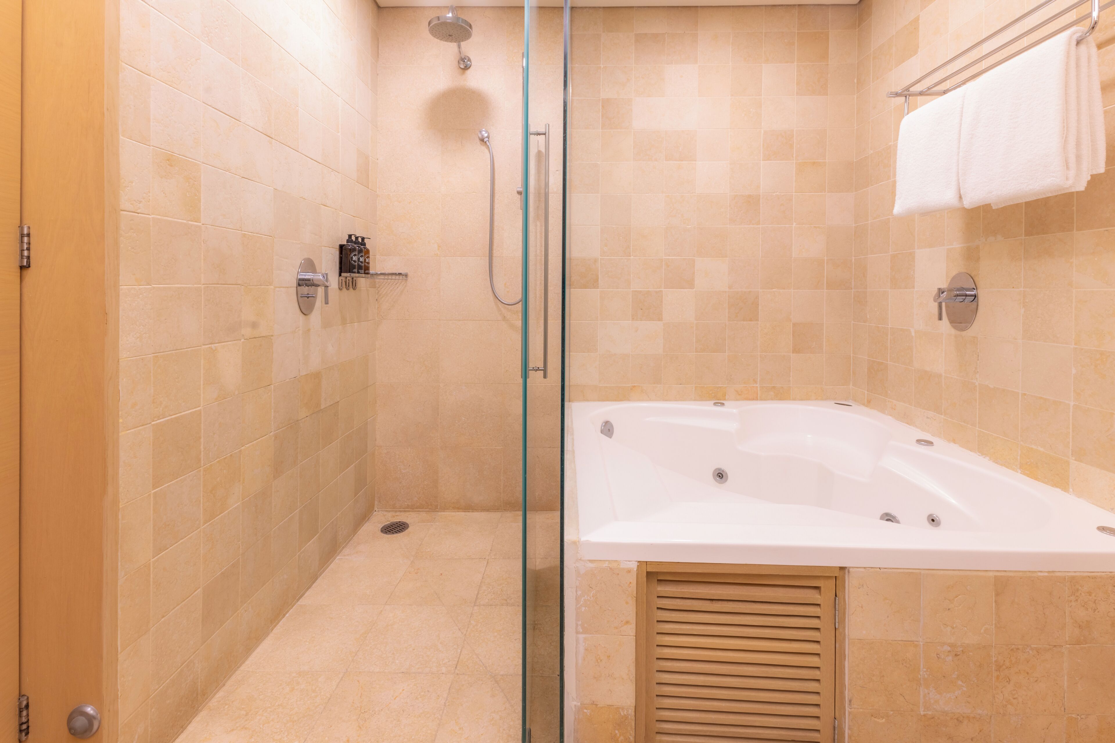 A modern bathroom with a glass-enclosed shower, a standalone bathtub, and a towel rack.