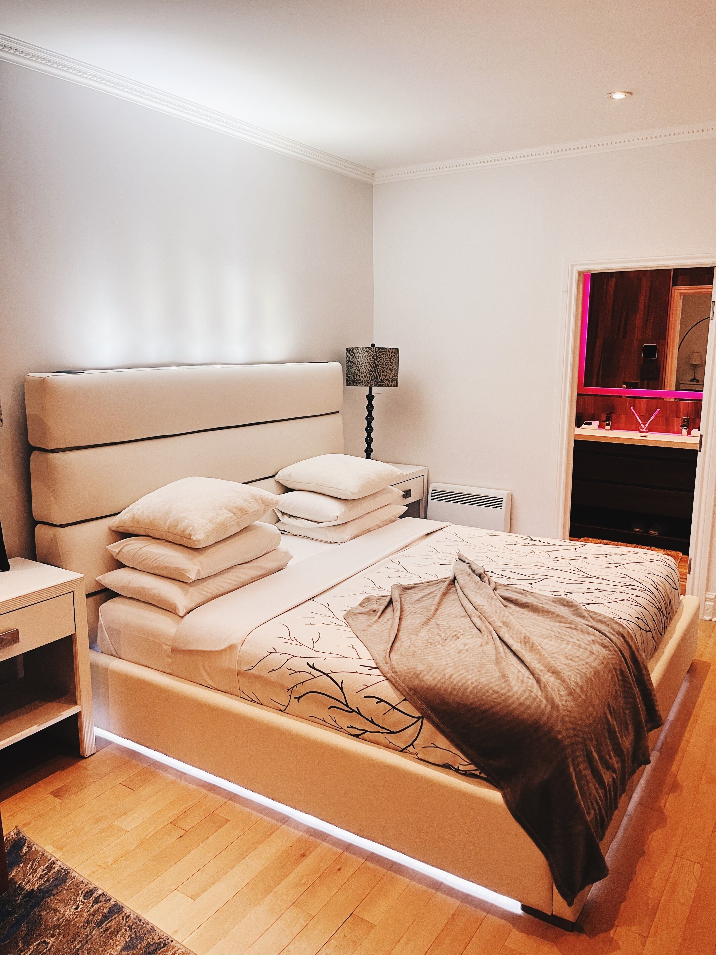 A bedroom with a bed, bedside tables, a lamp, and a wardrobe.