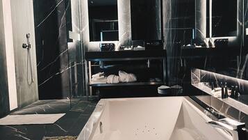 A modern bathroom with a large bathtub, a glass shower enclosure, and a vanity with a mirror.