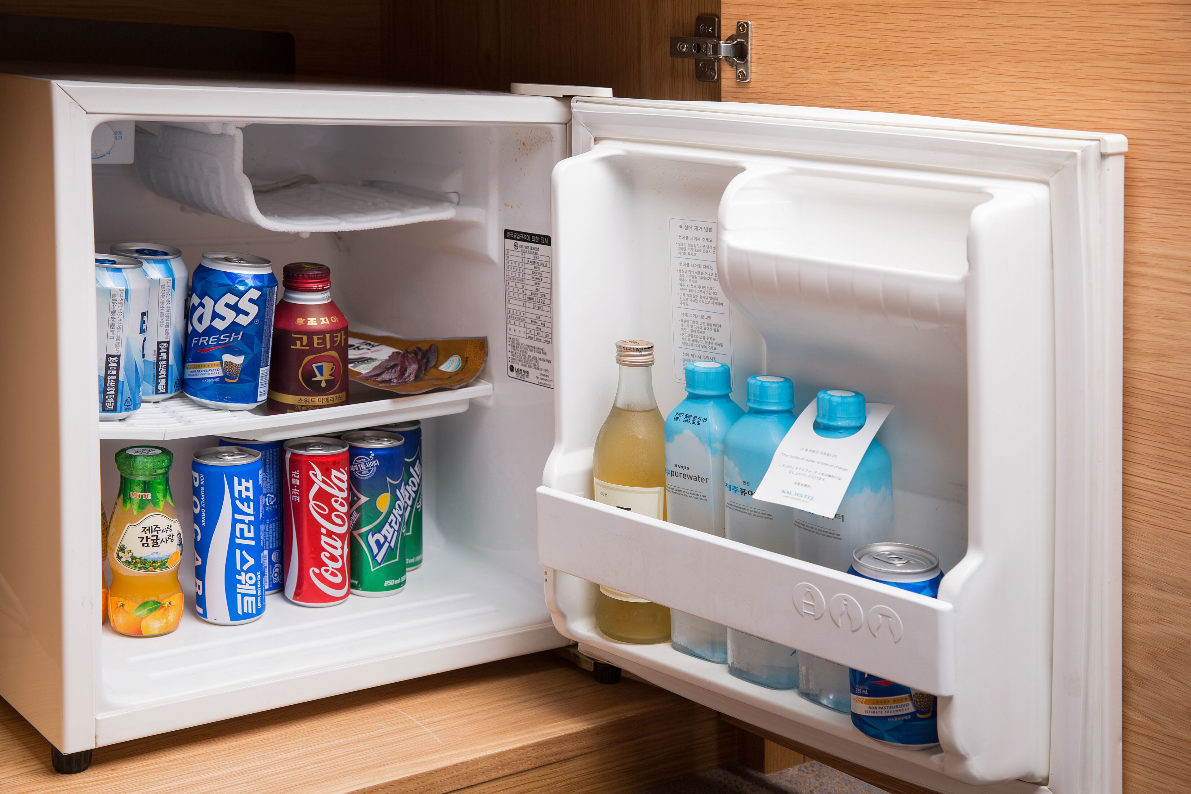An open refrigerator with various beverages and cans.