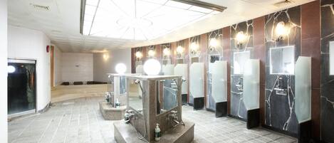 Eine öffentliche Toilette mit mehreren Waschbecken, Spiegeln und Beleuchtung.