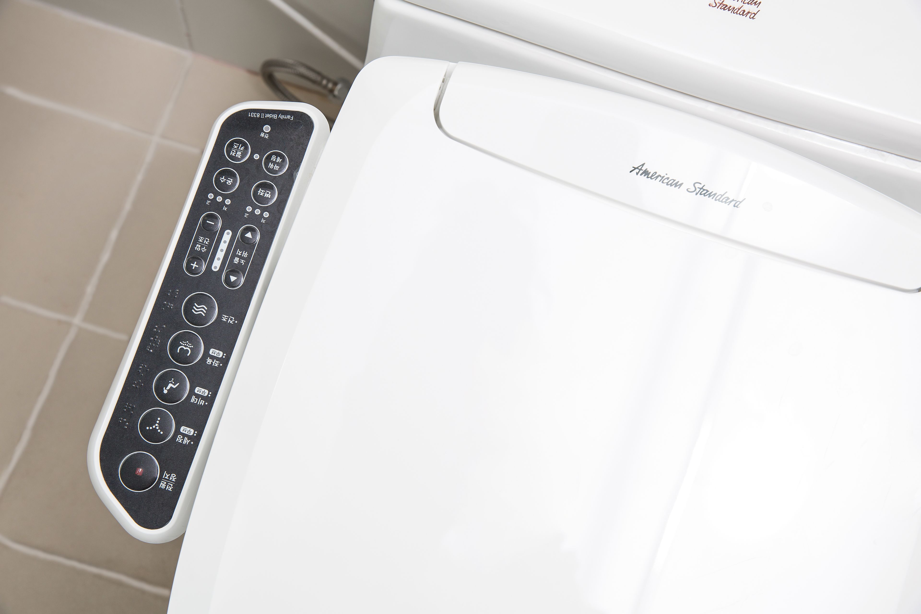 A white appliance with a control panel featuring various buttons and symbols.