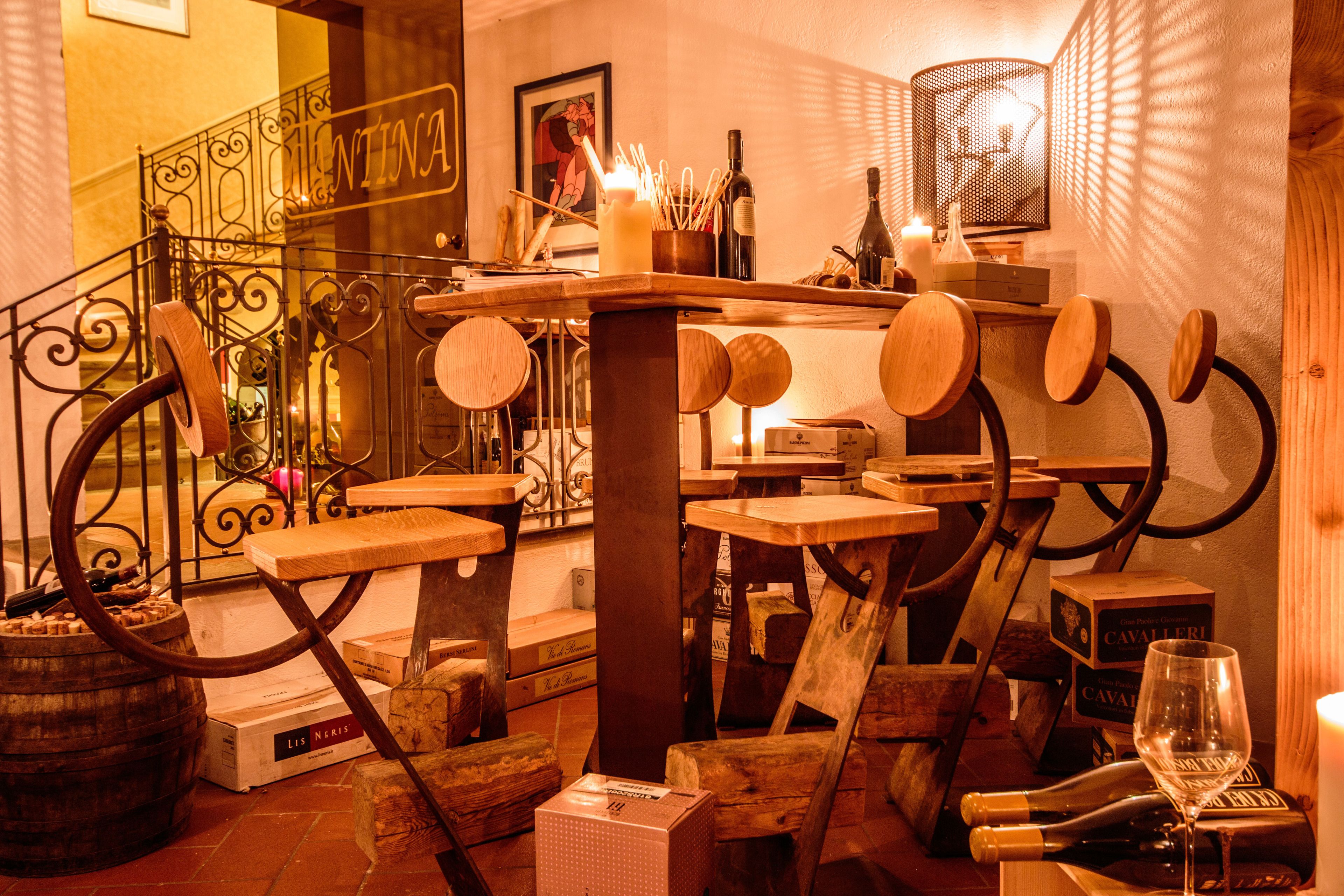 Eine Bar mit Holmöbeln, Weinflaschen und Gläsern.