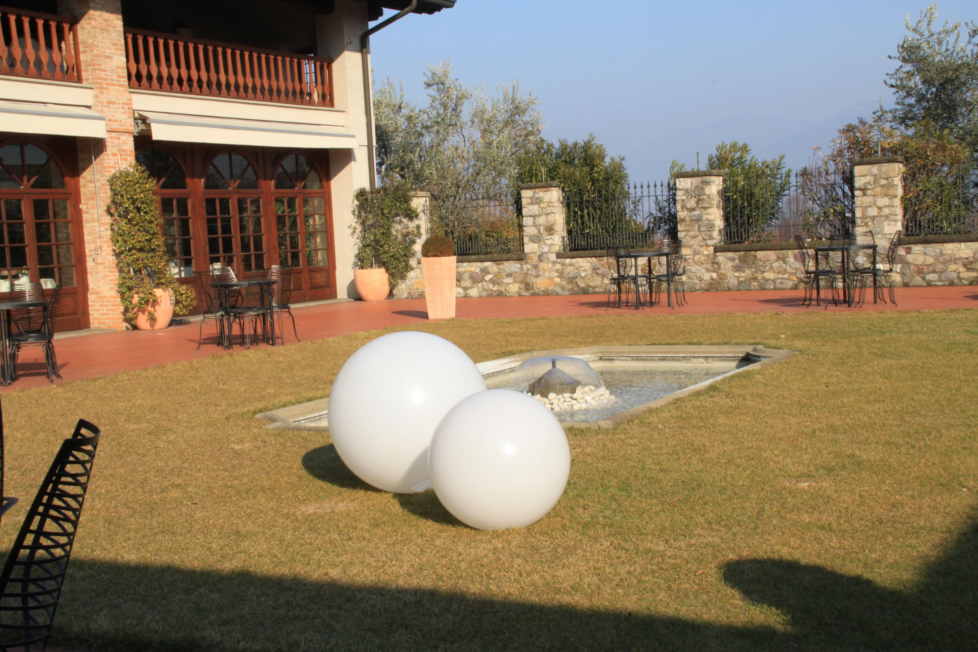 A courtyard with outdoor seating, a stone wall, and a water feature.