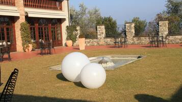 A courtyard with outdoor seating, a stone wall, and a water feature.
