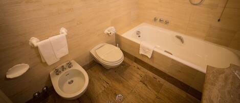 Ein Badezimmer mit Toilette, Bidet, Waschbecken und Badewanne.