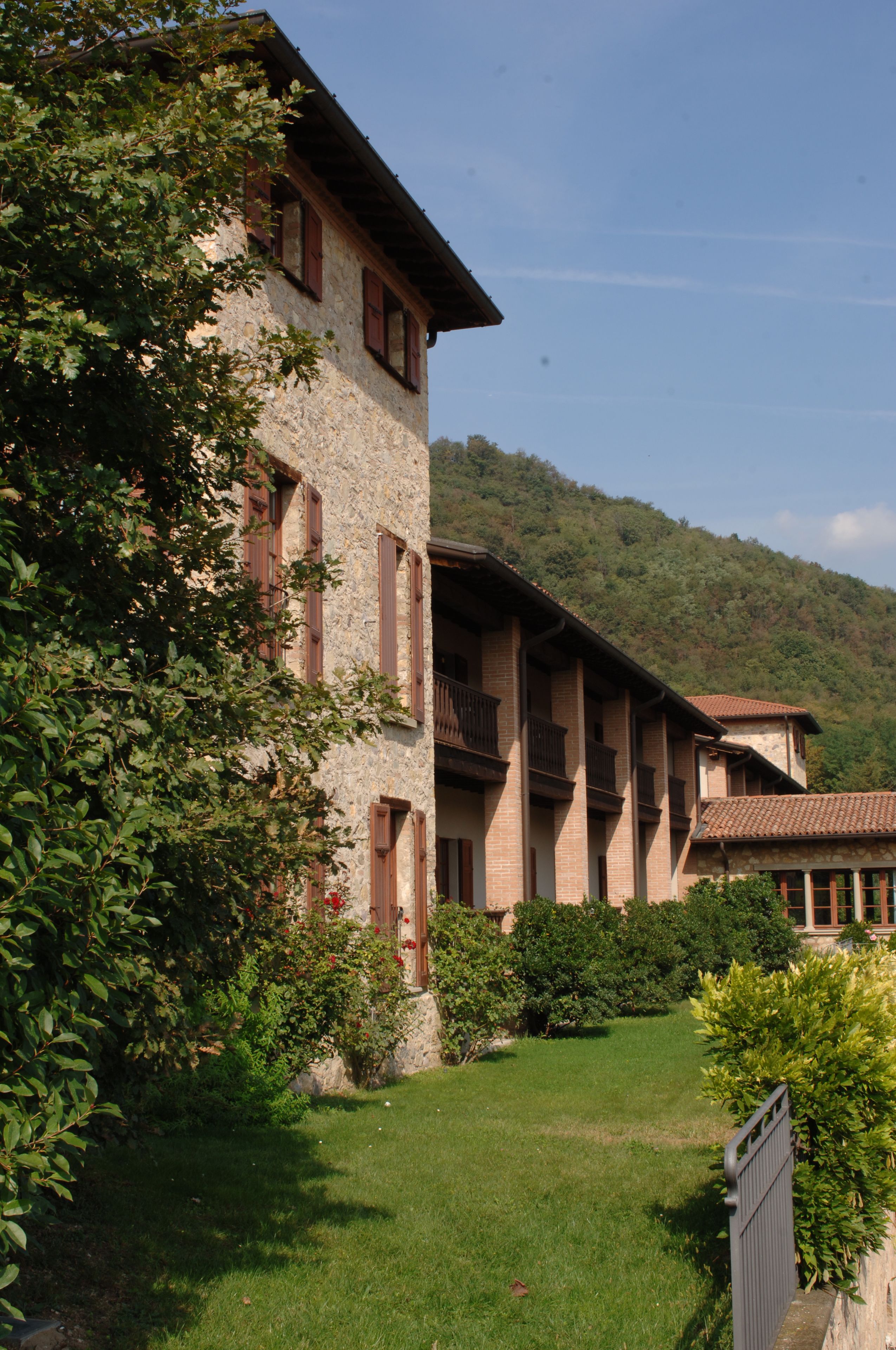 A stone building with multiple balconies and a garden in front.