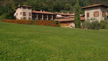 A stone building with multiple balconies and a garden with orange flowers.