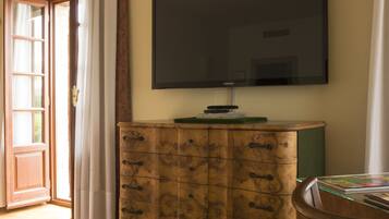 Ein Zimmer mit einem Holzkasten, einem Flachbildfernseher und einem Holzsessel.