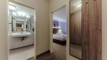 Ein Hotelzimmer mit Bad, einem Bett und einem Holzschrank.