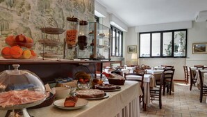 A buffet setup with various food items and a dining area with tables and chairs.