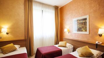 Copriletto in piuma, una scrivania, postazione laptop, tende oscuranti