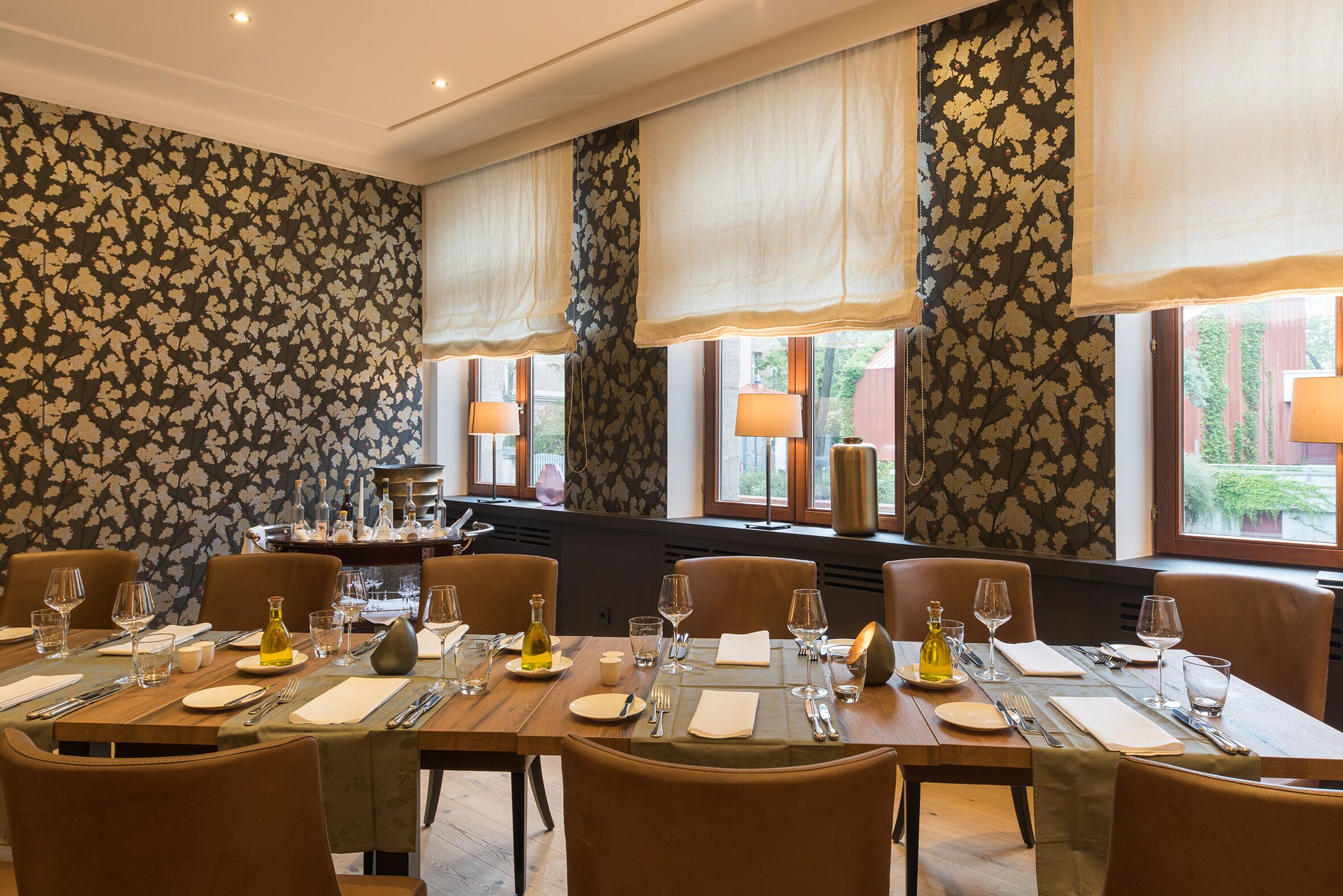 A dining area with a long table set for a meal, surrounded by chairs.