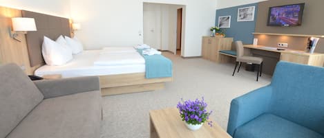 Une chambre d’hôtel avec un lit, un bureau, une chaise et un canapé.