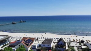 Un pueblo costero con playa, muelle y edificios con paneles solares.