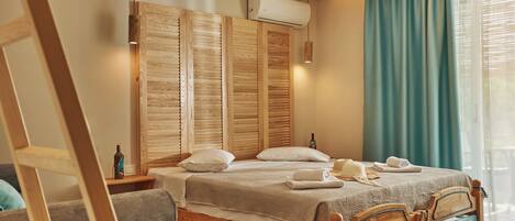 A wooden bed with a headboard, a bedside table with a bottle, and a window with curtains.