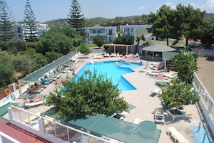 Una piscina al aire libre, sombrillas, sillones reclinables de piscina
