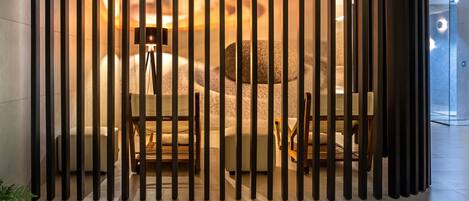 Een modern interieur met een zithoek, een stenen muur en een glazen scheidingswand.