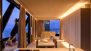 A modern hotel room with a large window, a bed, a bathroom, and a dining area. - Victoria Palace Hotel (Cattolica)