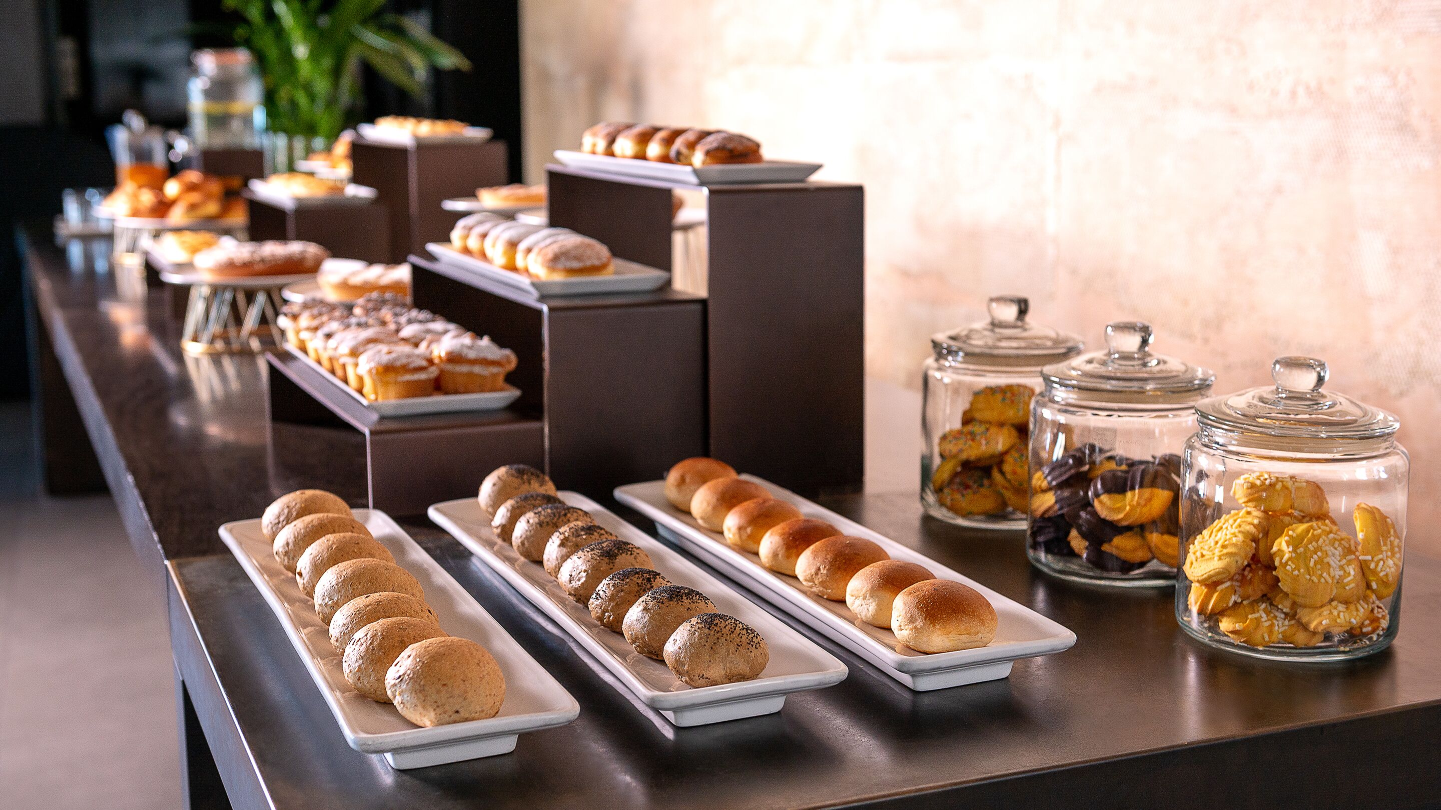 Una mesa de buffet con diversas opciones de panadería y pastelería.