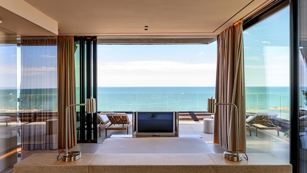 A modern hotel room with a large bed, a flat-screen TV, and a balcony with a view of the sea. - Victoria Palace Hotel (Cattolica)