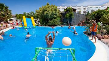 A swimming pool with inflatable slides and a netted goalpost.