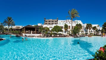 Una gran piscina al aire libre con varios niveles y palmeras.