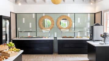 Een moderne keuken met twee zwarte aanrechtbladen, een glazen vitrine en een koffieapparaat.