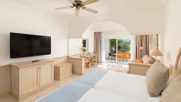 Une chambre d’hôtel avec un lit, une télévision, un bureau et un balcon offrant une vue.