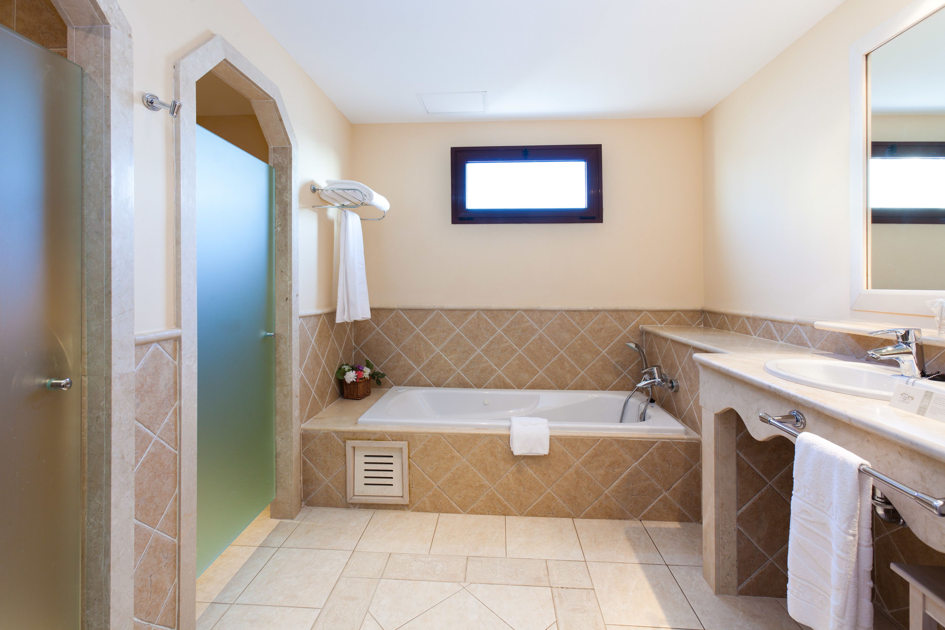 A modern bathroom with a bathtub, a sink, and a shower area.
