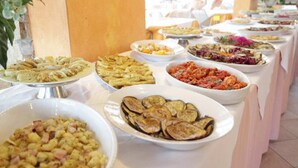 Una mesa de buffet con diversos platos, como pasta, ensaladas y verduras.