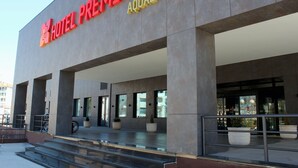 A hotel entrance with a modern design, featuring large columns and a prominent sign.