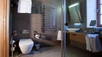 Un baño moderno con inodoro, lavamanos y cabina de ducha de vidrio.