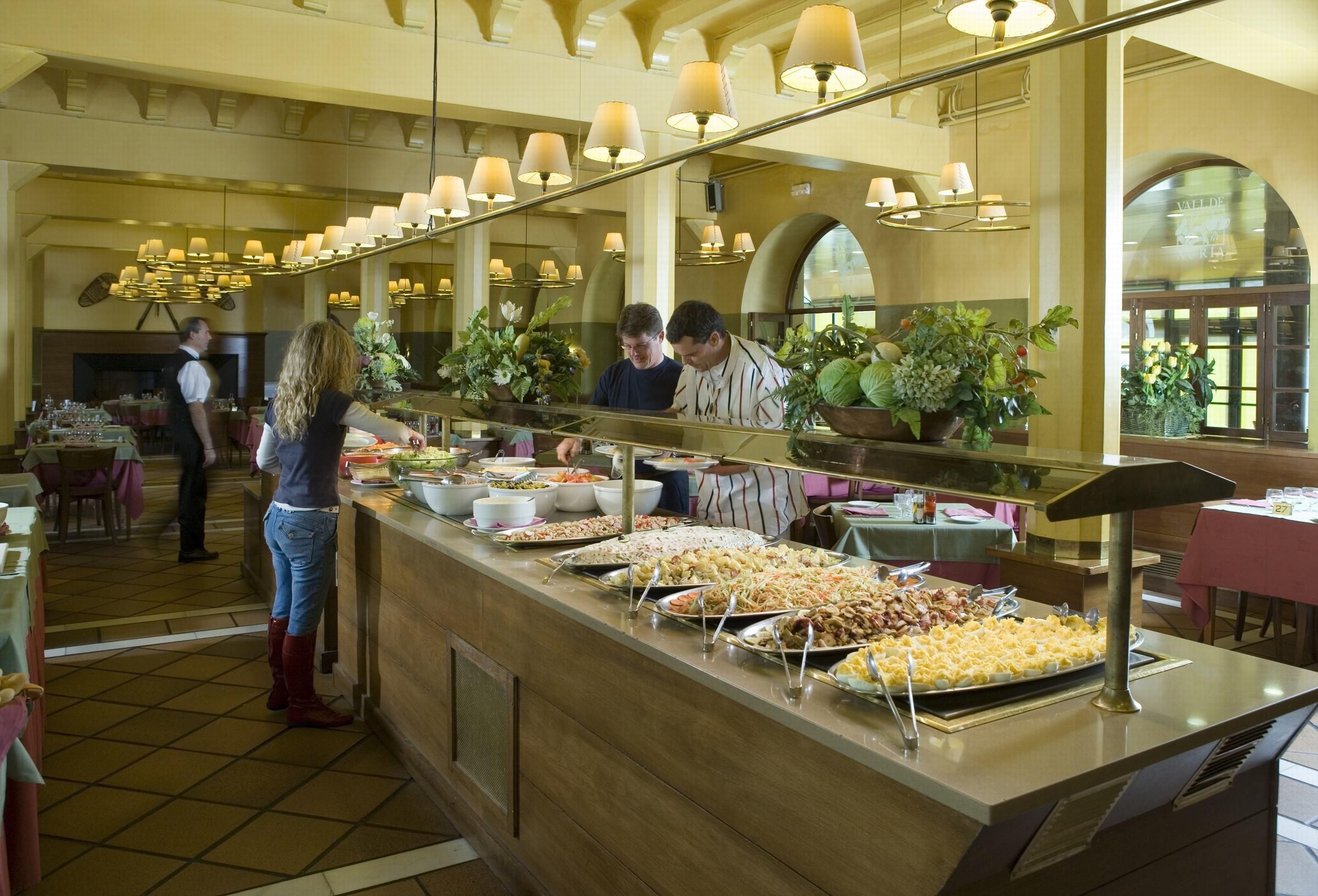 Een buffetgedeelte met verschillende etages en een grote spiegel die de ruimte weerspiegelt.
