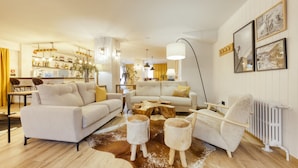 A modern living room with a sofa, armchairs, a coffee table, and a cowhide rug. - Hotel Viella (Vielha e Mijaran)