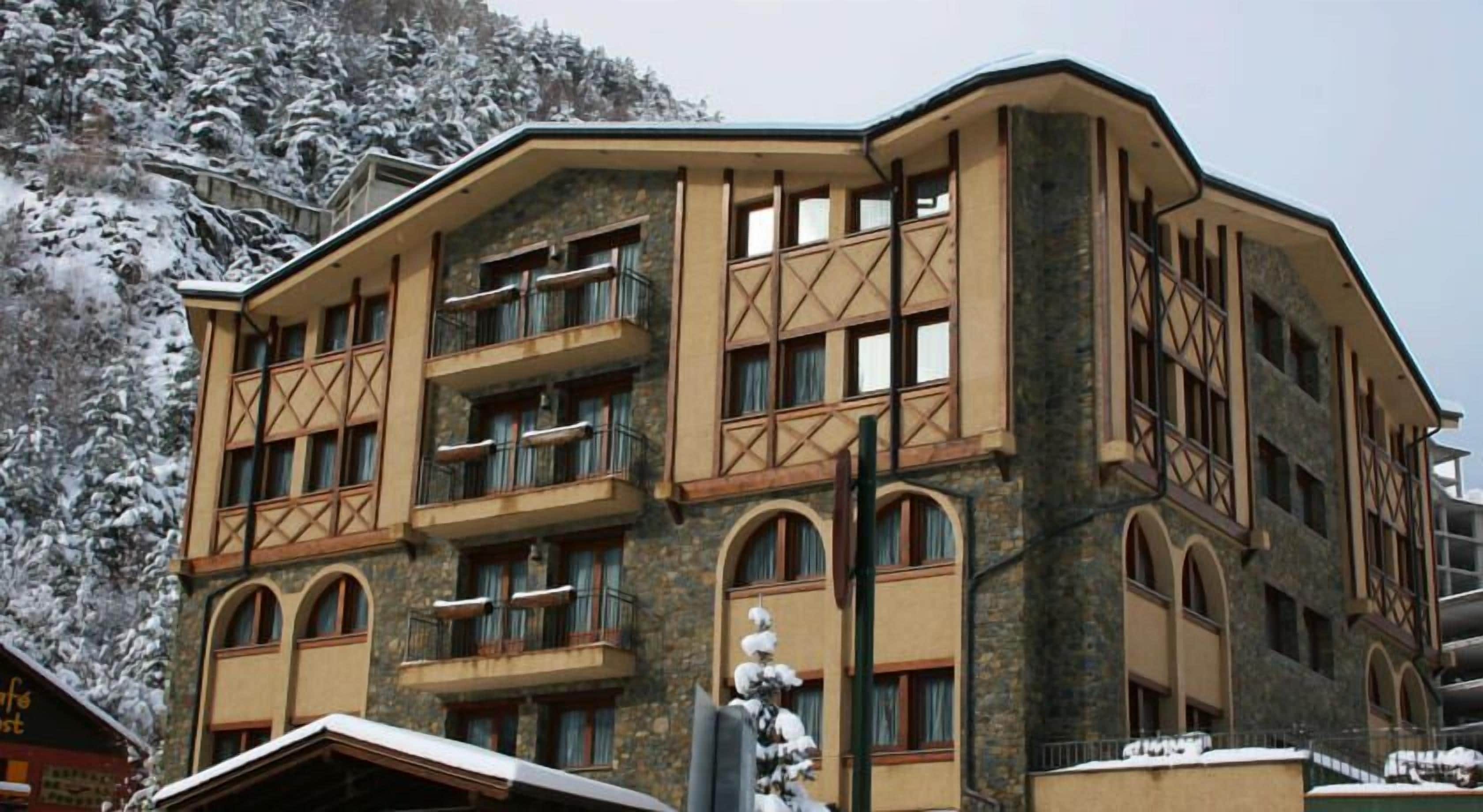 Un hôtel à plusieurs étages, doté d’une façade en pierre, de nombreux balcons et de fenêtres en arc de cercle.