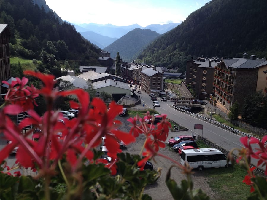 Une ville de montagne traversée par une route, entourée de bâtiments et de verdure.