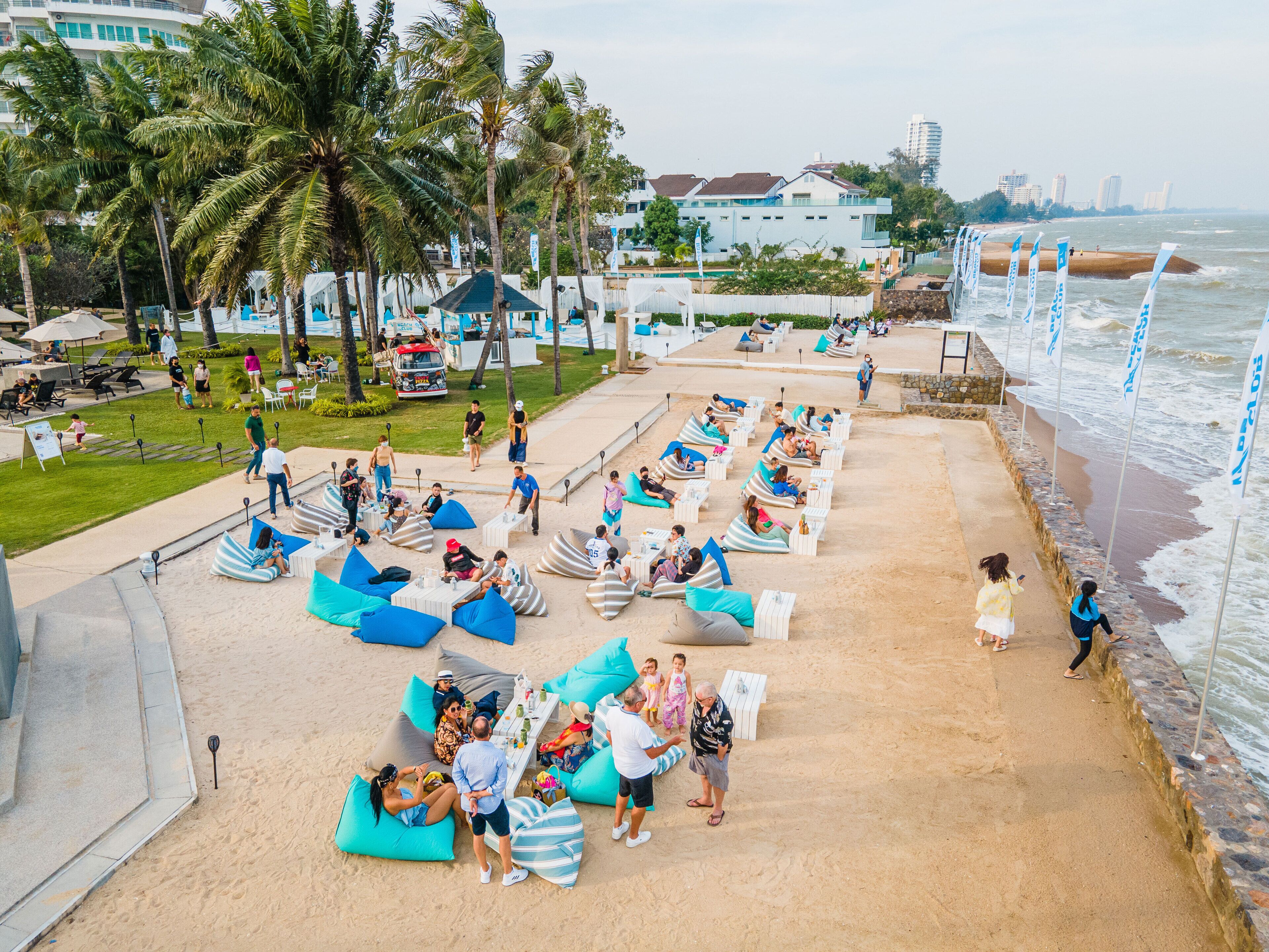 Un resort frente a la playa con sillones de descanso y sombrillas, una zona de piscina y vistas al océano.