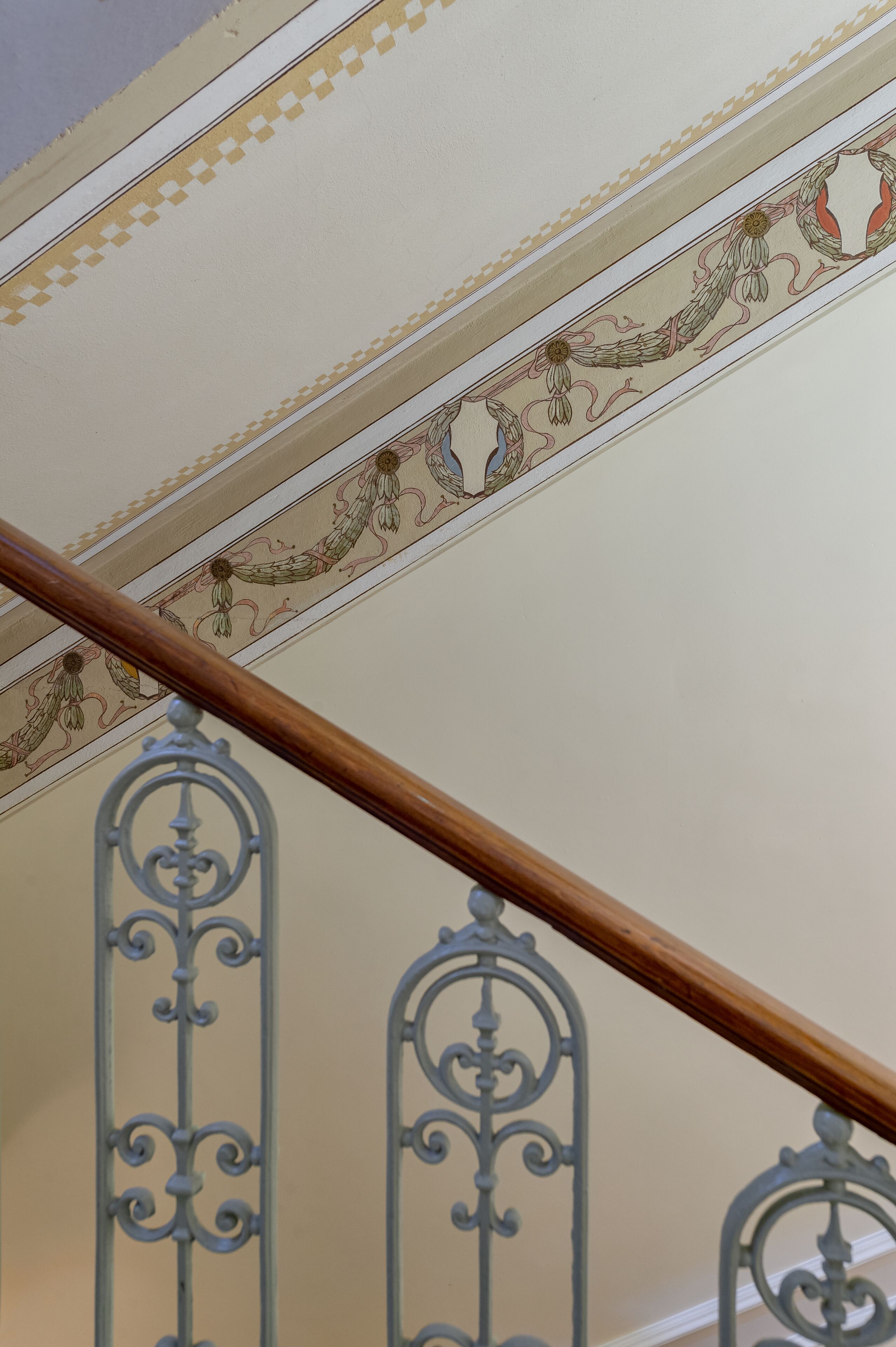 A staircase with ornate metal railings and decorative ceiling trim.
