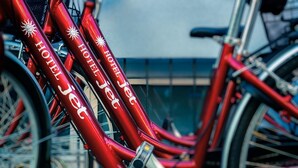 A red bicycle with "HOTELJET" branding and sun symbols. - Jet Hotel (Jesolo)