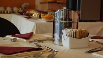 A table set with cutlery, a glass container with napkins, and a menu holder.